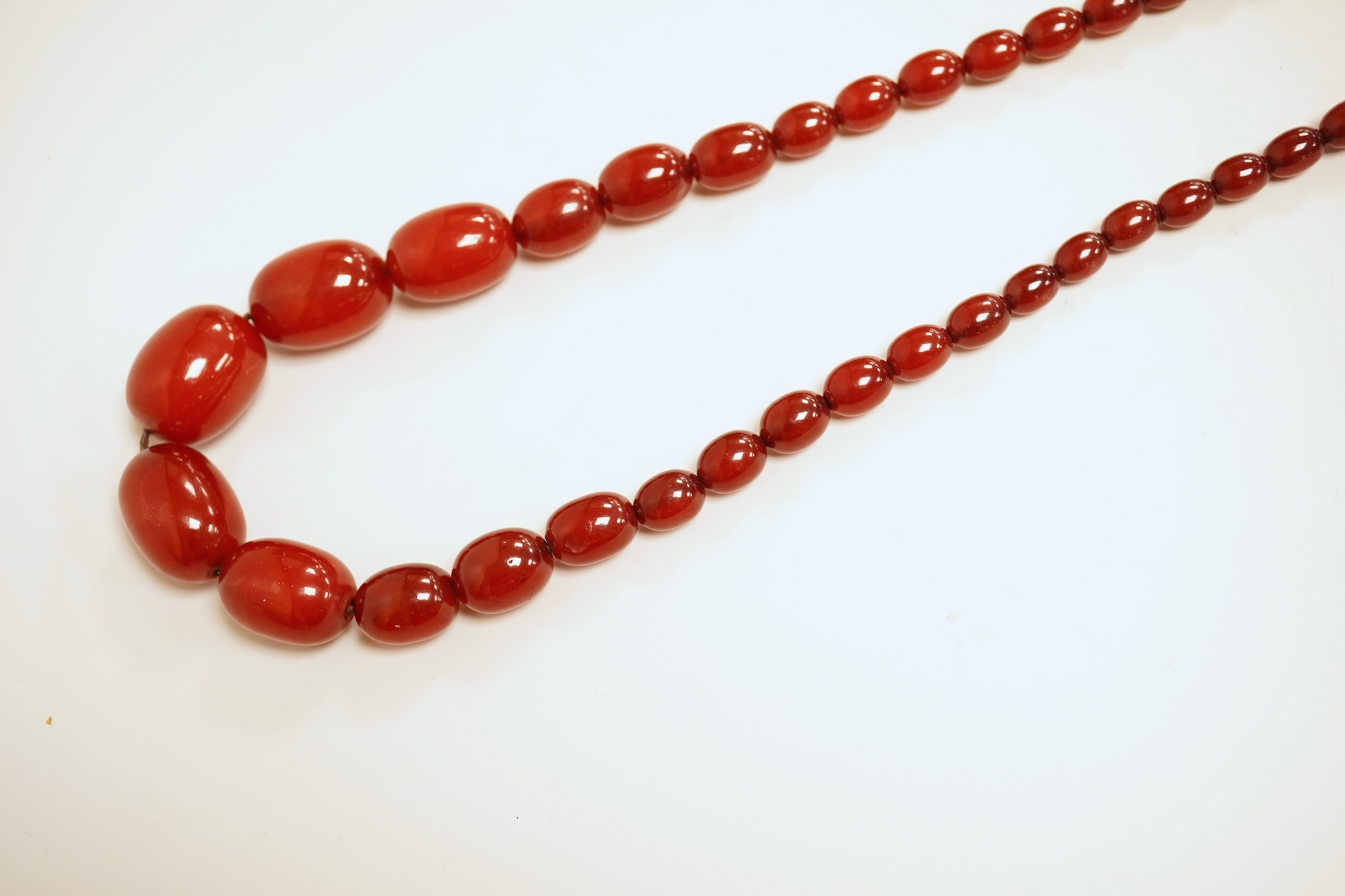 A single strand graduated simulated cherry amber bead necklace, 76cm, gross weight 75 grams.
